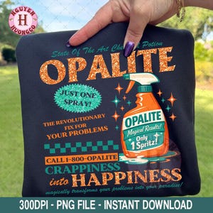 May include: Black graphic design featuring the word "OPALITE" in glittery orange letters. The design includes a spray bottle with the text "Magical Results! Only 1 Spritz!" and the phrase "Crappiness into Happiness."