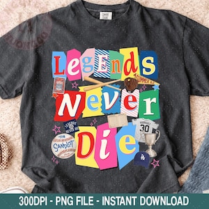 May include: Dark gray t-shirt with a colorful graphic that reads "Legends Never Die." The design includes baseball-themed elements like bats, a glove, a baseball, and a baseball cap. The shirt has a vintage, distressed look.