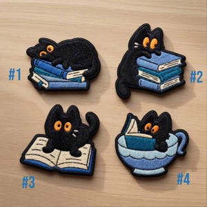 Könnte beinhalten: Set aus vier gestickten Aufnähern mit schwarzen Katzen mit orangefarbenen Augen und weißen Schnurrhaaren. Jede Katze interagiert mit Büchern oder einer Teetasse. Die Aufnäher sind mit #1 bis #4 nummeriert und befinden sich auf einer hellbraunen Oberfläche.