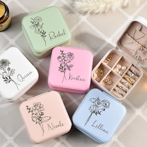 May include: Five small square jewelry boxes with floral designs and personalized names: Rachel, Quinn, Kristen, Nicole, and Lillian. Each box has a different color: green, white, pink, light pink, and light blue.