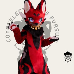 May include: A red and black furry costume of a fox with a white chest and white paws. The costume has a black collar with gold beads. The costume is standing on a white background.