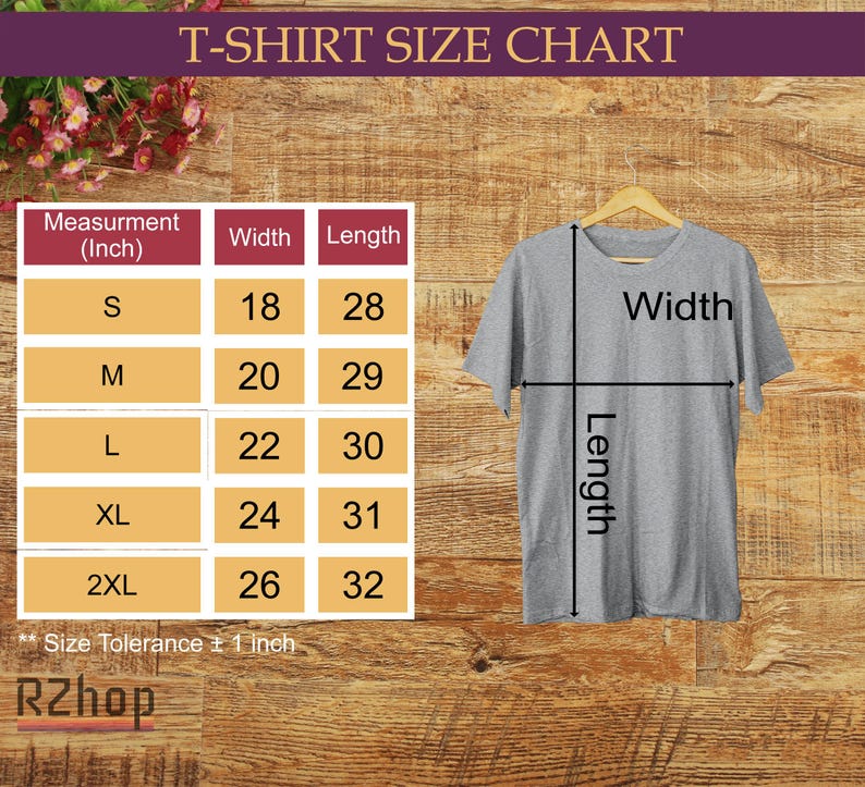 Op de afbeelding: Een grijs t-shirt hangt aan een houten hanger, met een maattabel links. De tabel toont de afmetingen in inches voor breedte en lengte, van maat S tot 2XL. De tekst "T-SHIRT SIZE CHART" staat bovenaan.