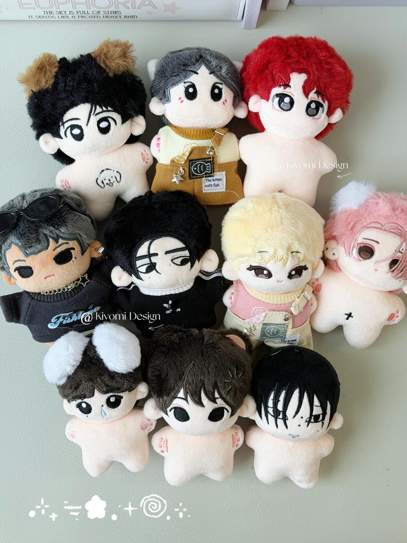 May include: A collection of plush dolls with various hairstyles and outfits. The dolls have large eyes and are in a variety of colors, including black, brown, red, and blonde. Some dolls have accessories like sunglasses or overalls. The text "@kivomi Design" is visible.
