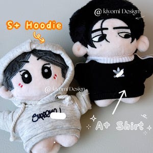 May include: Two plush dolls, one in a gray hoodie with the text "Supreme" and the other in a black shirt with a white logo. Both dolls have black hair and cartoon-style faces. The text "S+ Hoodie" and "A+ Shirt" are also visible.