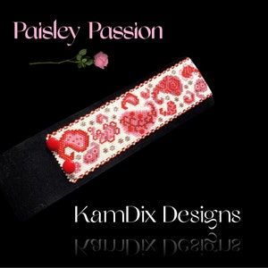 May include: A white beaded bracelet with a red and pink paisley pattern. The bracelet is on a black background and the text "Paisley Passion" and "KamDix Designs" is visible.
