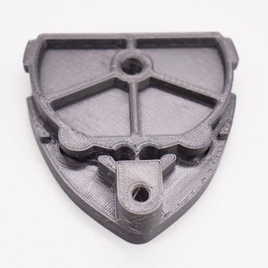 May include: A 3D printed black plastic camera mount with a tripod screw hole and a slot for a camera strap.