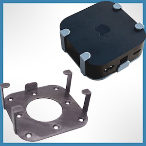 May include: A black Apple TV media streaming device with a gray wall mount bracket. The device has a white Apple logo on the front.