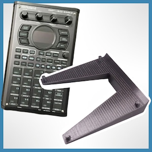 May include: A black Roland SP-404MKII sampler with a black plastic stand. The sampler has a variety of buttons and knobs, including a large central knob, and a small LCD screen.