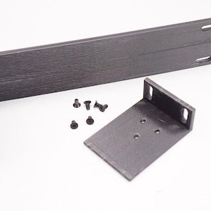 May include: Two black plastic brackets with five black screws. The brackets are designed to be mounted to a wall or other surface.