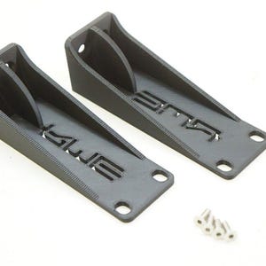 Pode incluir: Dois suportes de plástico preto com a palavra "SLUR" impressa neles. Os suportes têm furos para parafusos. São incluídos quatro parafusos prateados.