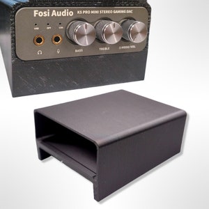 May include: Black Fosi Audio K5 Pro Mini Stereo Gaming DAC with USB, optical, and coaxial inputs. The device has three knobs for bass, treble, and mode/volume control.