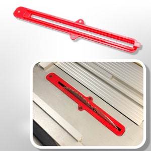 Puede incluir: Protector de hoja de sierra de mesa de plástico rojo con una ranura para la hoja. El protector está diseñado para ajustarse sobre la hoja y proteger al usuario de lesiones.