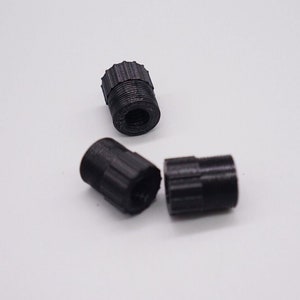 May include: Three black plastic caps with a threaded design. The caps are used for covering the ends of pipes or tubes.