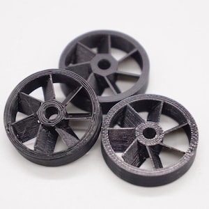 May include: Three black plastic wheels with a six-spoke design. The wheels have a small hole in the center.