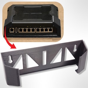 Puede incluir: Soporte de pared negro para un router de red u otro dispositivo electrónico. El soporte tiene una forma rectangular con un recorte para el dispositivo y una serie de recortes triangulares para la ventilación.