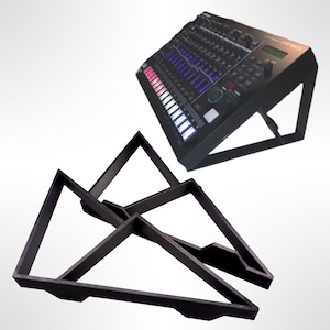 Pode incluir: Suporte triangular preto para um dispositivo de produção musical. O suporte é feito de plástico resistente e é projetado para elevar o dispositivo para melhor visibilidade e acessibilidade. O suporte é dobrável e compacto para fácil armazenamento.
