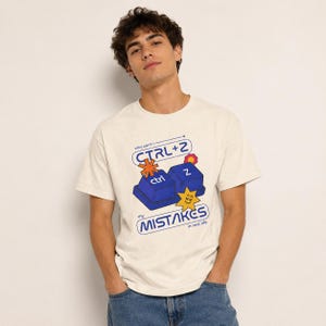 Pode incluir: Uma t-shirt de manga curta cor de creme com um gráfico de duas teclas de teclado de computador azuis com as etiquetas ctrl e z. O texto diz why can't i CTRL+Z my MISTAKES in real life, acompanhado por ícones em forma de estrela.