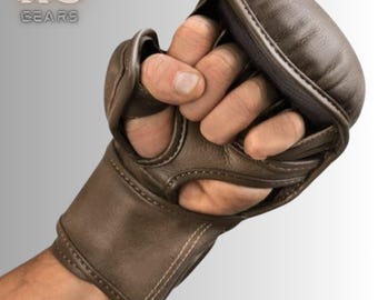 May include: Brown leather training gloves with a wrist strap and finger holes. The gloves have a padded palm and a textured surface.