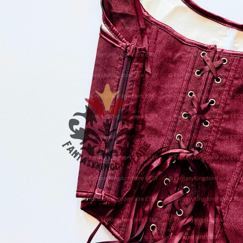May include: Close-up of a burgundy corset with a corduroy texture. The corset features a zipper closure and ribbon lacing. The image includes the text "Fantasy Kingdom Faire ETSY".