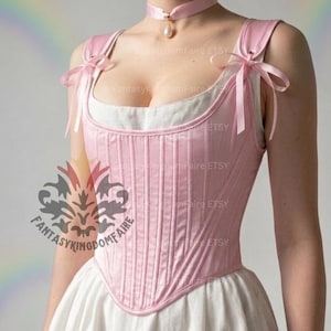 May include: A light pink corset with vertical stitching and a sweetheart neckline. The corset has pink straps tied with bows and is worn over a white garment. A pink choker with a pearl pendant is also visible.