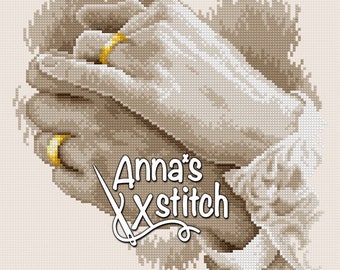 May include: A cross-stitch pattern of two hands holding each other, with a gold ring on each finger. The pattern is in shades of brown and beige, and the text "Anna's Xstitch" is visible in the lower right corner.