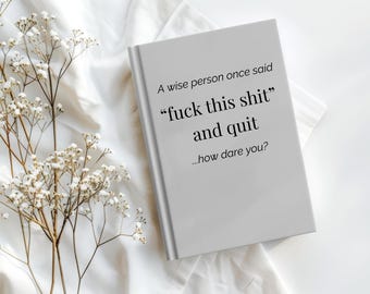 May include: A light gray book with the text "A wise person once said 'fuck this shit' and quit...how dare you?" is displayed on a white surface. Delicate white flowers and stems are in the background.