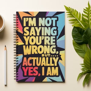 May include: A spiral bound notebook with a colorful geometric design and the text "I'm not saying you're wrong, but... actually yes, I am."