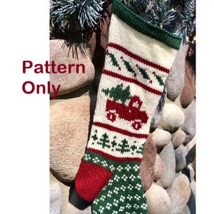 May include: Knitted Christmas stocking with a red truck carrying a green Christmas tree, green holly leaves, and red berries. The stocking is white with red and green stripes. The text "Pattern Only" is visible in the image.