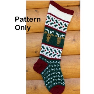May include: Knitting pattern for a Christmas stocking featuring a reindeer design. The stocking is red, white, and green with a brown reindeer face. The pattern is called "Christmas Stocking Reindeer" and is by Cindy Steinberg.