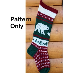 Könnte beinhalten: Strickmuster für einen Weihnachtsstrumpf mit einem weißen Eisbären auf grünem Hintergrund mit roten und weißen Streifen. Der Strumpf liegt auf einer Holzoberfläche. "Pattern Only" ist in weißer Schrift auf schwarzem Hintergrund geschrieben.