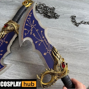 Può includere: Due spade ornate in stile fantasy con dettagli blu e oro. Le lame hanno una forma unica con intricati dettagli dorati e una gemma rossa. Le impugnature sono nere con dettagli dorati. È presente anche una catena d'argento.
