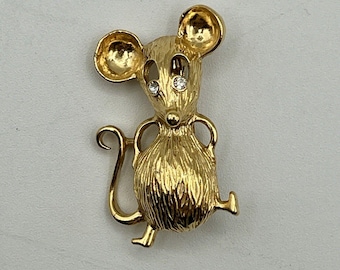 May include: A gold-toned mouse brooch with sparkling clear rhinestones for eyes.