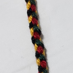 May include: A braided cord with black, red, and gold threads.