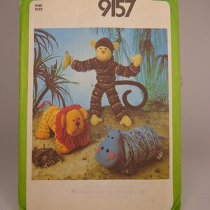 May include: Simplicity sewing pattern number 9157 for making stuffed animals. The pattern includes instructions for making a monkey, a lion, and a hippopotamus. The pattern is for one size.