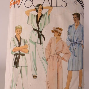 May include: A sewing pattern for three different robes. The pattern is from McCall's and is labeled "Easy McCall's". The robes are in different colors and styles. One is a light blue robe with a black sash, another is a pink robe with a white sash, and the third is a blue and white striped robe with a white sash.
