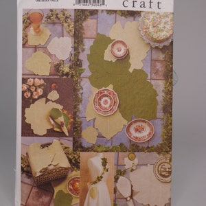 May include: A Vogue Craft sewing pattern for making leaf-shaped coasters. The pattern is for one size and features a photo of the finished coasters with a variety of colors and designs.