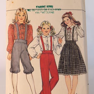 May include: A Butterick 4679 sewing pattern envelope featuring illustrations of three outfits: a red gingham shirt with gray knickers, a white blouse with red suspender pants, and a white polka dot blouse with a plaid skirt.