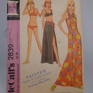 May include: Vintage McCall's sewing pattern envelope for a dress and skirt. The pattern is for misses' sizes 12-34 and features a floral print dress and a wrap skirt. The envelope also includes the text "Valeta's Yarn 'N Yard Goods 120 E. Superior Munising, Mich. 49862".
