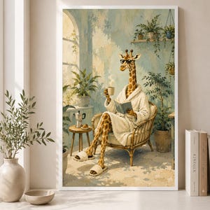 Op de afbeelding: Een ingelijste muurkunstprint met een giraf in een witte badjas, zonnebril en slippers, zittend in een rieten stoel terwijl deze een boek leest en een koffiemok vasthoudt, met kamerplanten, een bijzettafel en een koffiepot in de scène.