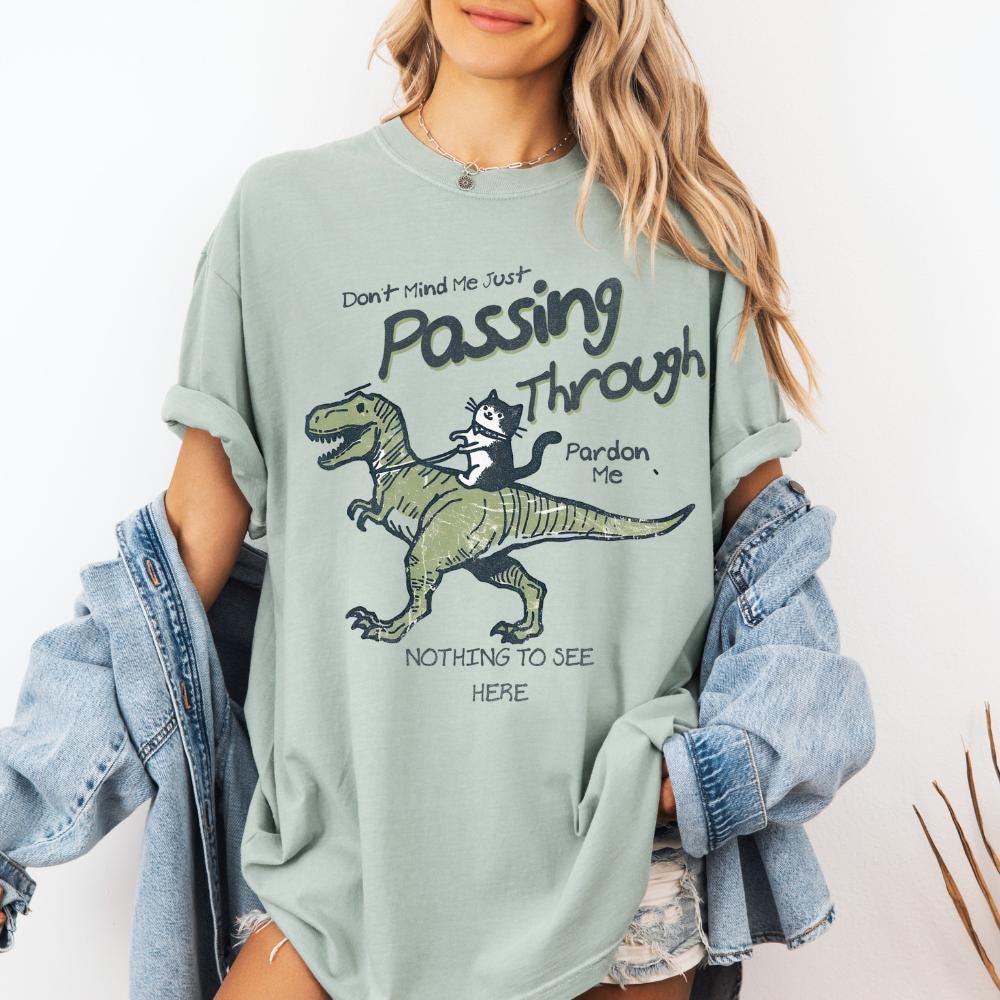 Don't Mind Me Just Passing Through T Shirt, Funny Cat Riding T-rex Shirt, Cute Gift T Shirt for Cat Lovers and T-Rex Lovers alike