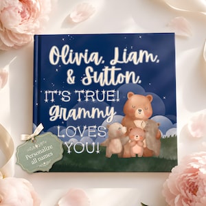 May include: A square hardcover book with a dark blue night sky cover featuring four illustrated brown bears and the text: Olivia, Liam, & Sutton. IT'S TRUE! Grammy LOVES YOU! A sage green tag attached to the book reads: Personalize all names.