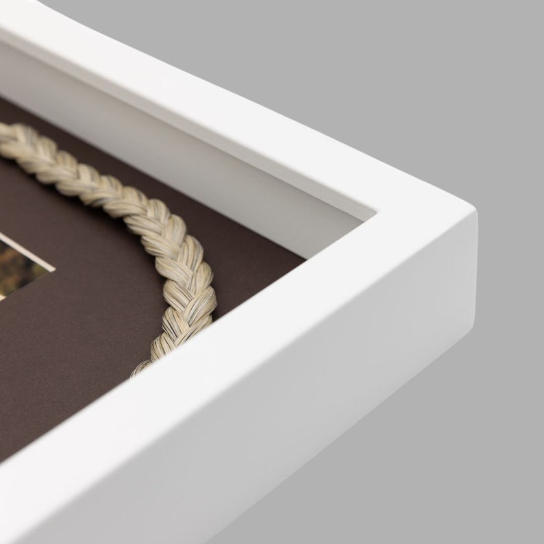 May include: White picture frame with a brown mat and a rope-like border. The frame is made of wood and has a simple, modern design.