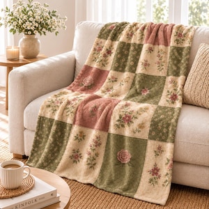 May include: A rectangular throw blanket featuring a patchwork design of alternating squares. The pattern consists of cream, sage green, and dusty rose blocks, each decorated with detailed floral prints of roses and small wildflowers.