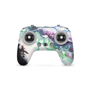 May include: A drone controller with a white base and a colourful abstract design in shades of purple, green, and blue. The controller has two joysticks, buttons, and the DJI logo.