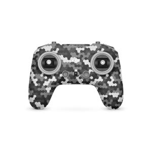 May include: A drone remote control with a camouflage pattern in shades of grey and white. The controller has two joysticks, several buttons, and a power button. The DJI logo is visible on the front.
