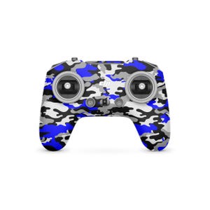 May include: A drone controller with a blue, white, black, and gray camouflage pattern. The controller has two joysticks, several buttons, and the DJI logo. The design is a mix of digital and military camouflage.