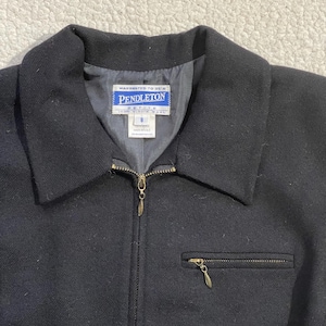May include: Black wool jacket with a collar, a zipper closure, and a small zippered pocket. The jacket features a label that reads "Pendleton Petite". The jacket is size 8.