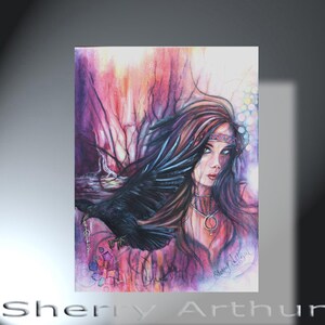 May include: A colorful artwork featuring a woman with long brown hair and a raven. The woman wears a headband and necklace. The background has a mix of pink, purple, and white hues. The raven is black and has a gold chain. The artist's name, Sherry Arthur, is at the bottom.