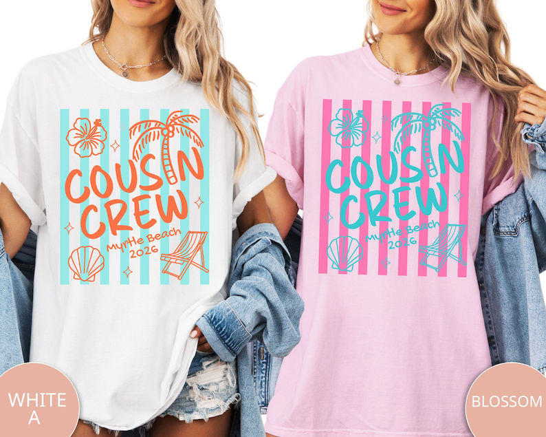Op de afbeelding: Een wit t-shirt en een lichtroze t-shirt, elk met een grafische print van verticale strepen, een hibiscusbloem, een palmboom, een schelp en een strandstoel. De tekst luidt COUSIN CREW Myrtle Beach 2026 in oranje of blauwgroene inkt.