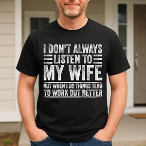 May include: Black t-shirt with white text that reads "I DON'T ALWAYS LISTEN TO MY WIFE BUT WHEN I DO THINGS TEND TO WORK OUT BETTER". The shirt has a crew neck and short sleeves.